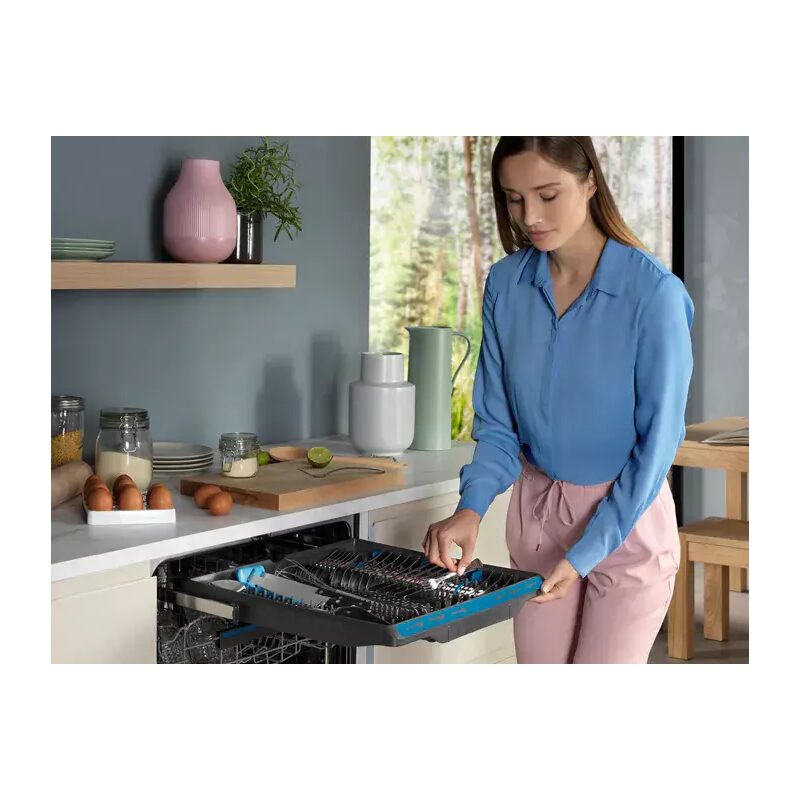 Femme charge un lave-vaisselle moderne dans une cuisine