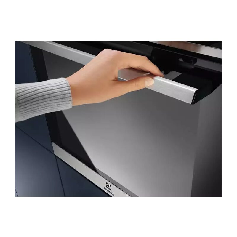 Main ouvrant un four encastrable en inox