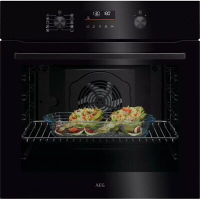 Four AEG avec plat de légumes cuits.