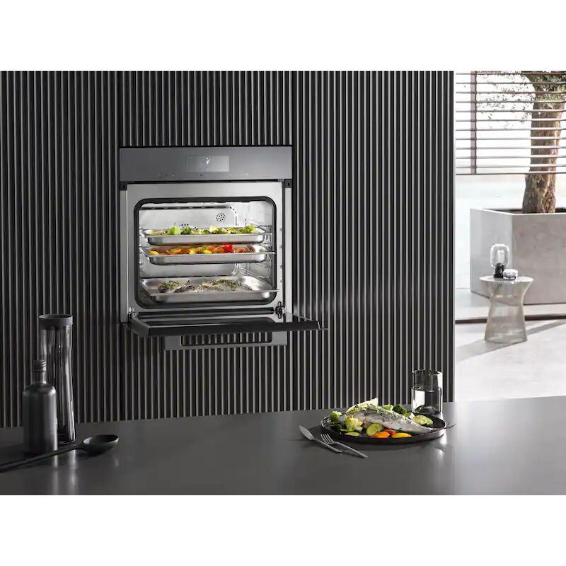 Four moderne avec plats de légumes cuits