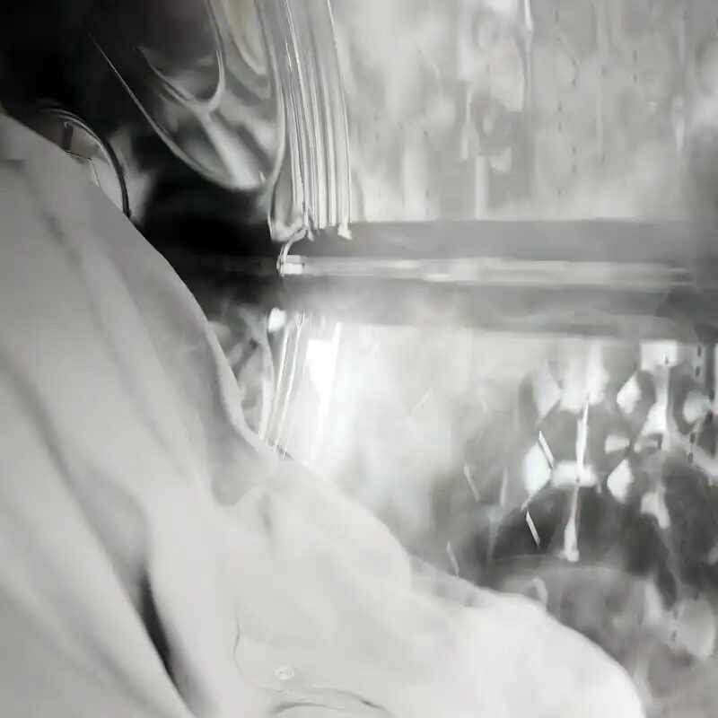 Chemise blanche dans un tambour de lave-linge fumant