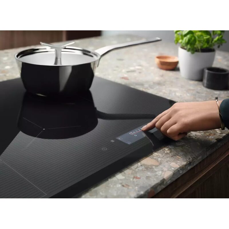 Main réglant plaque à induction moderne