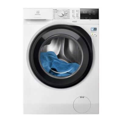 Lave-linge moderne avec serviette bleue à l’intérieur