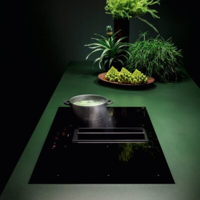 Plaque à induction noire avec casserole et légumes verts