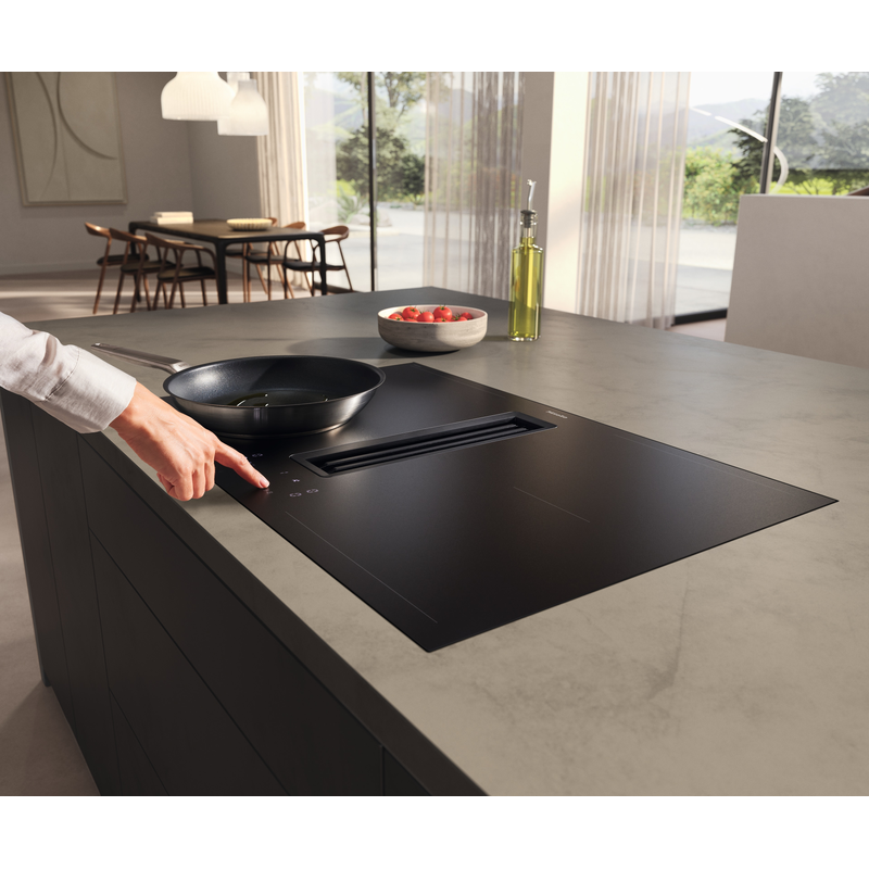 Main utilisant plaque à induction moderne noire