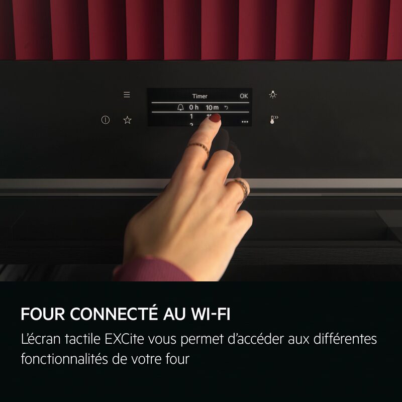 Main réglant écran tactile d’un four connecté