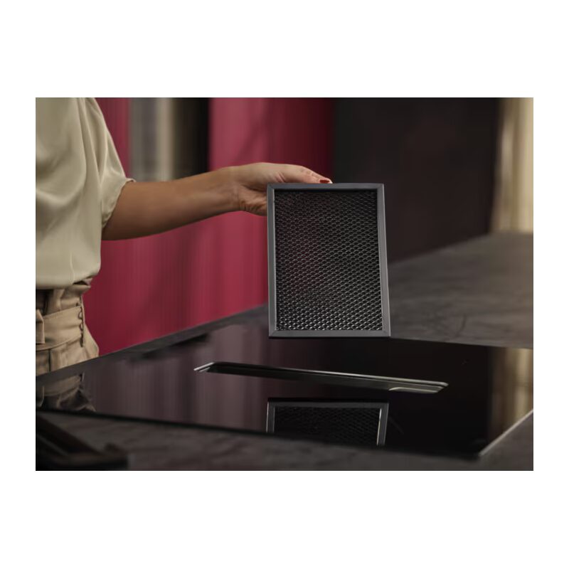 Filtre de hotte tenu au-dessus d’une plaque