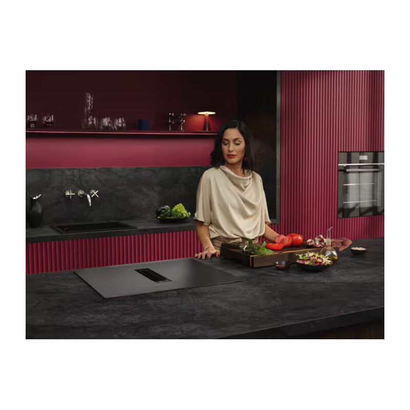 Femme préparant des légumes dans cuisine moderne rouge