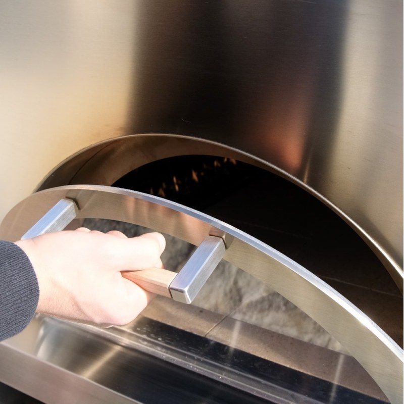 Main ouvrant la porte d’un four en inox