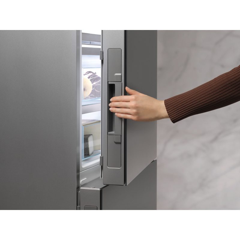 Main ouvrant un réfrigérateur moderne gris