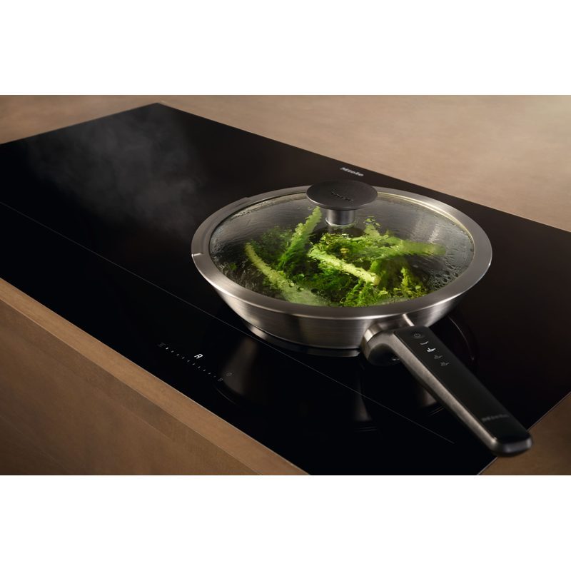 Poêle avec couvercle cuisant des légumes verts